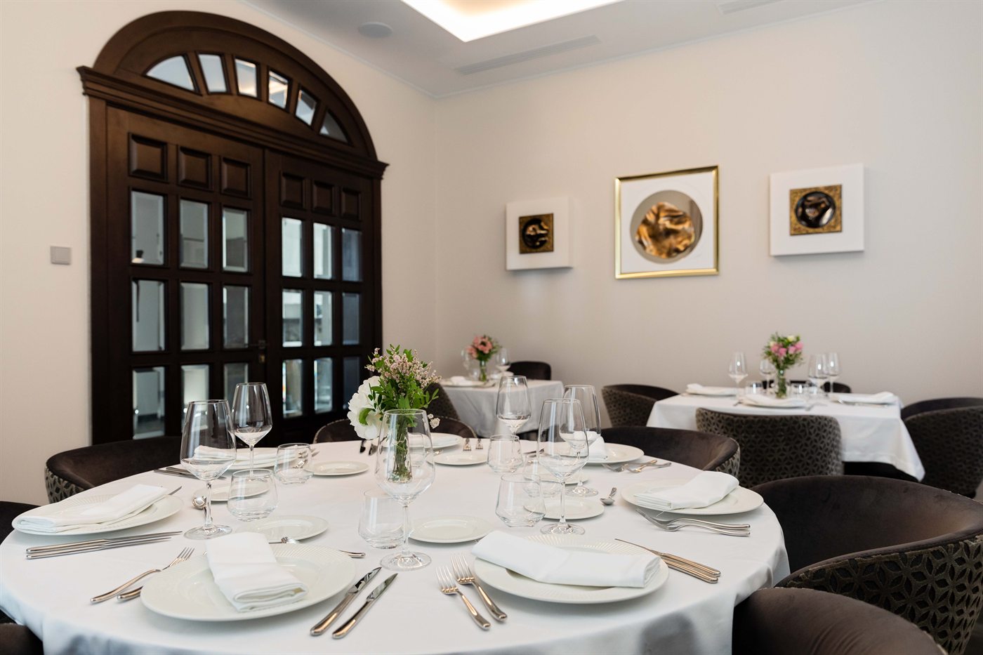 Uma mesa redonda posta para jantar na sala interior