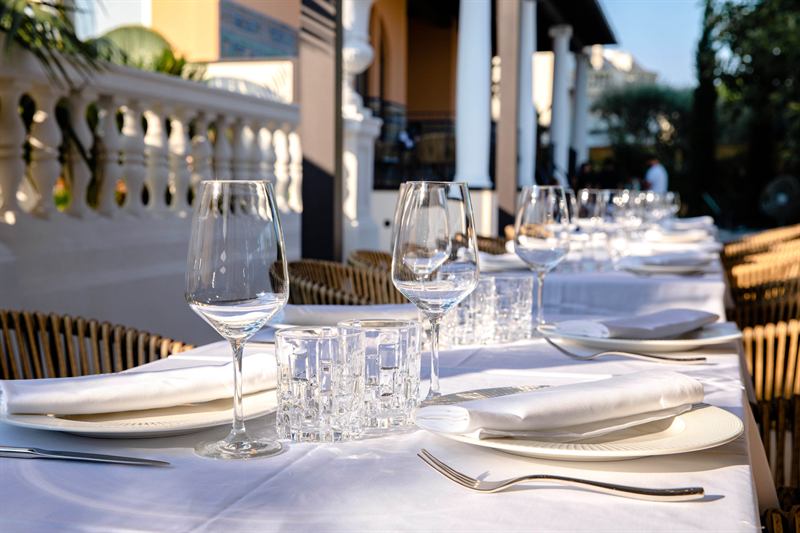 Tables laid on the covered terrace for a private dinner