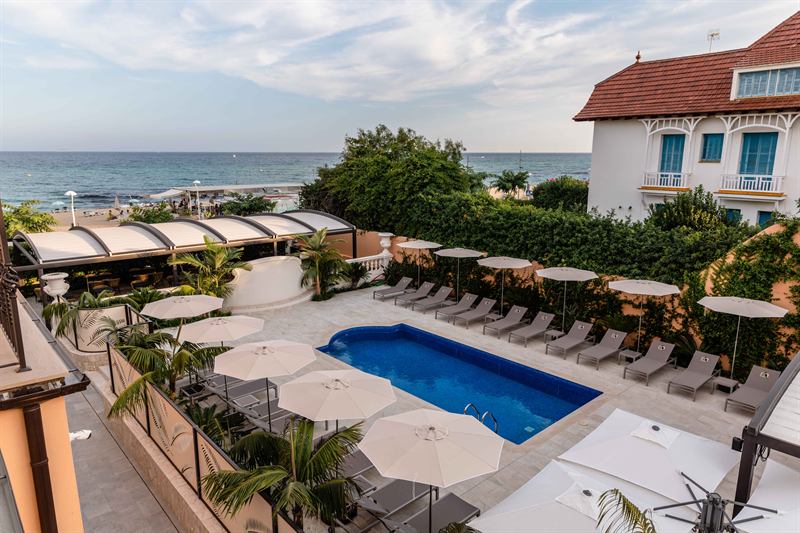 A piscina e as espreguiçadeiras com vista para o mar