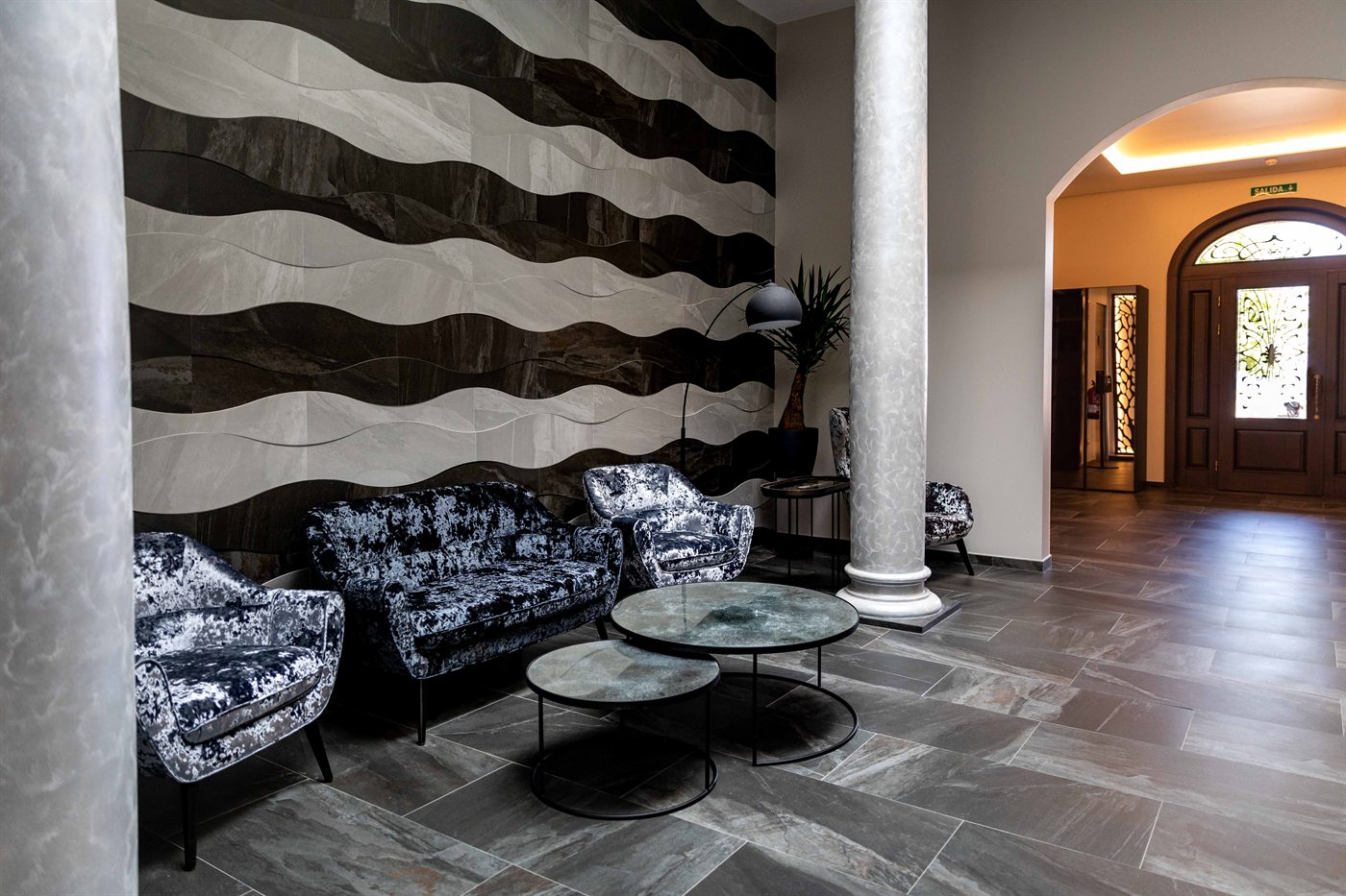 A sala interior, com poltronas diante de um muro de pedra lavrada